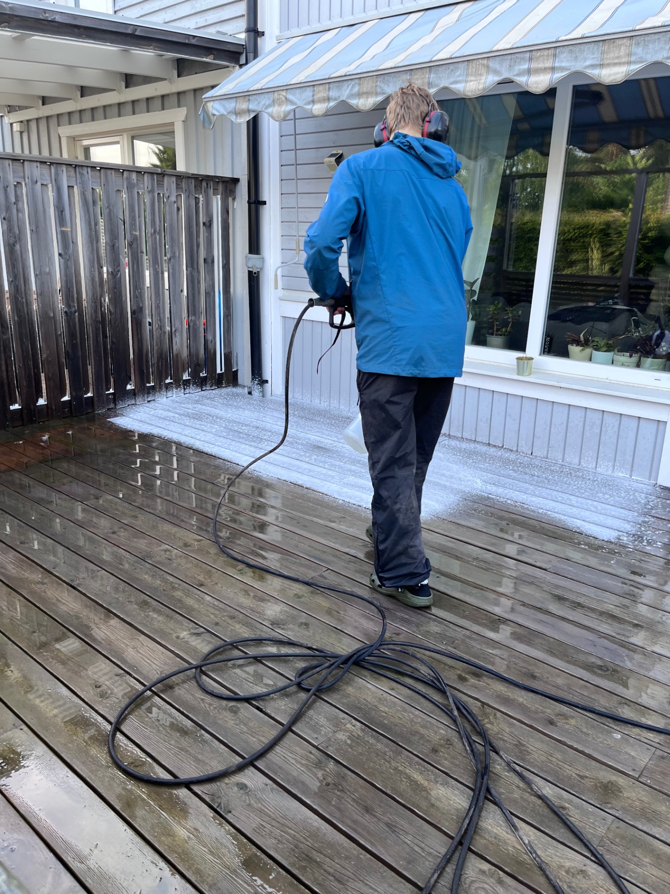 Altan i trä behandlas med foam under pågående högtrycksrengöring